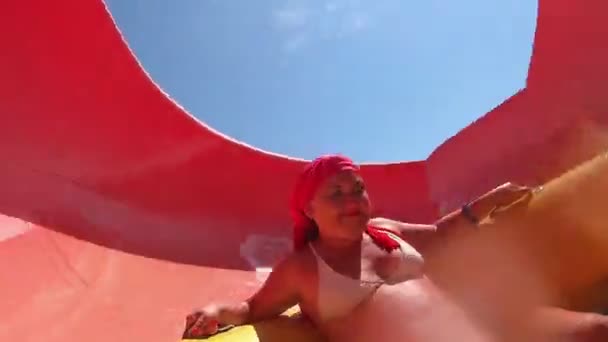 En ung kvinna i en simning cirkel sänker en vattenrutschbana och skrik från extrema sporter. — Stockvideo