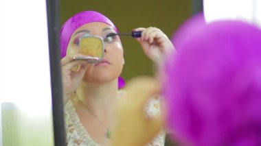 Evli bir Jewess aynaya yansıyan göz farı ile makyaj yapar
