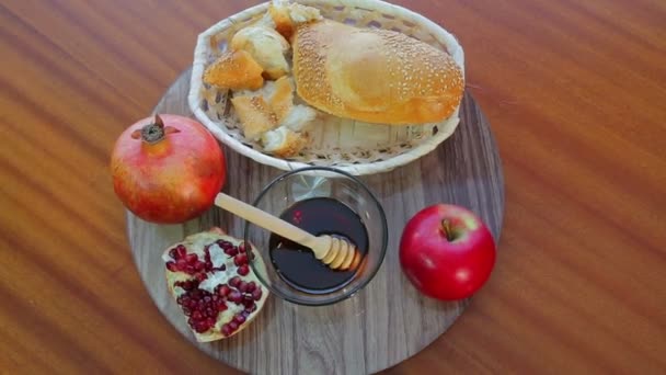 Leckereien für Rosh Anshan Granatäpfel, Honig und Challah auf einer Spinnschale. — Stockvideo