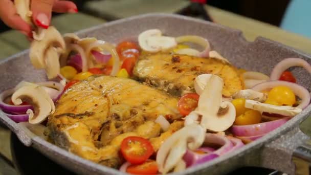 Mão feminina coloca champignon fatiado em peixe. voltas temporais — Vídeo de Stock