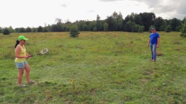 Erkek ve kadın aile tatilde badminton oynamak