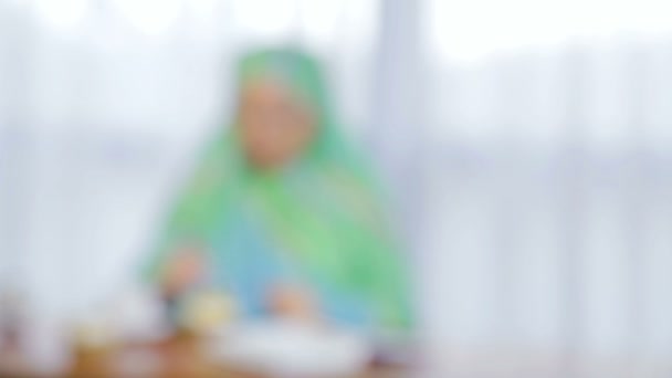 カフェで軽いスカーフをした若いイスラム教徒の女性がケーキを食べ、お茶を飲む — ストック動画