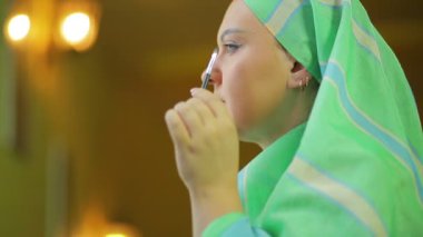 Müslüman kadın bir fırça ile bir ayna önünde