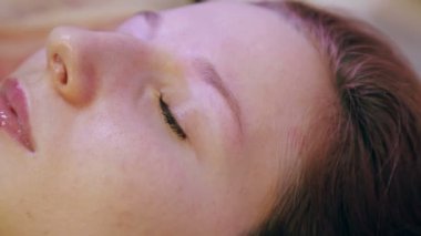 Beautician cımbız ve bir fırça ile müşterinin kaşları düzeltir.