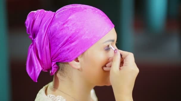 Żonaty Żydzi przed lustrem robi makijaż oczu z fioletowymi cieniami z pędzlem. — Wideo stockowe
