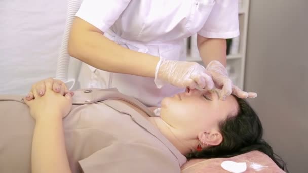 Den kosmetolog gör korrigering av ögonbrynen av klienten socker pasta — Stockvideo