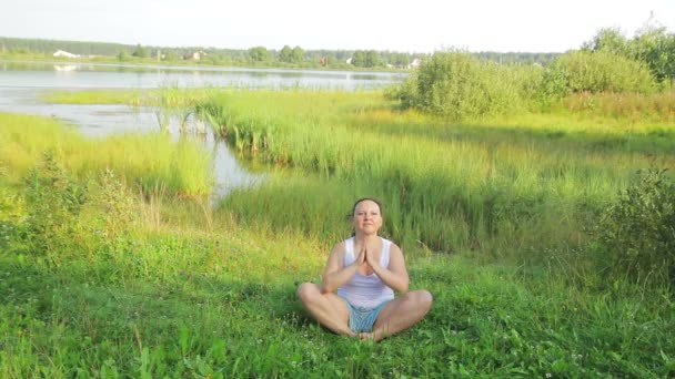 Брюнетка делает упражнения на озере утром — стоковое видео