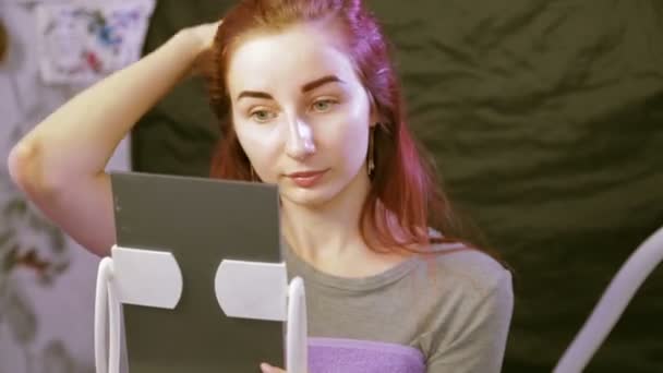 The client examines the eyebrows after the correction in the mirror. — Stock Video