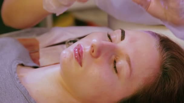 The beautician paints the client with an eyebrow with a special brush. — Stock Video