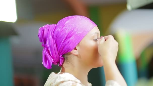 Een getrouwde Jewess voor de spiegel doet een lichte Oogmake-up met een borstel — Stockvideo