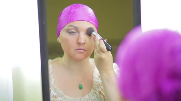 Un'ebrea sposata davanti allo specchio applica la fondazione con un pennello . — Video Stock
