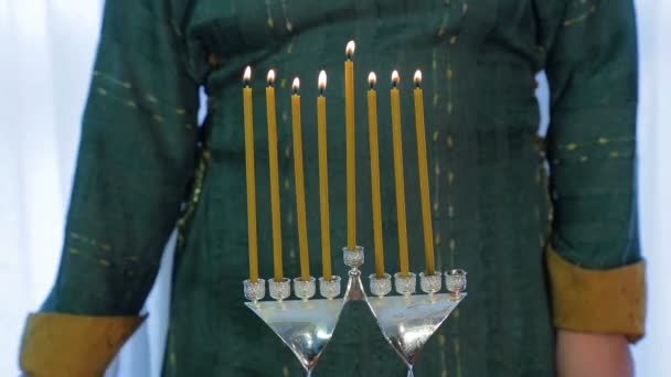 Mulher judia acende velas em Hanukkah em um belo castiçal — Vídeo de Stock