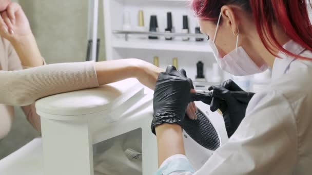 Manicure Master polerar klienternas naglar innan du applicerar gelen beläggning. — Stockvideo