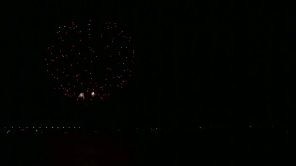 En färgstark spridning av festliga fyrverkerier på natthimlen ovanför älven reflekteras i vattnet. Tid varv. — Stockvideo