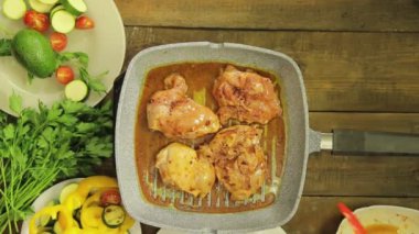 WOMANS el maşa ile bir ızgara Pan tavuk parçaları döner.