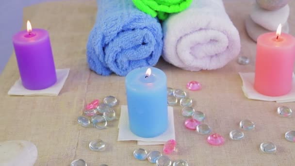 Mesa en el salón Spa con velas, toallas y piedras para terapia — Vídeos de Stock
