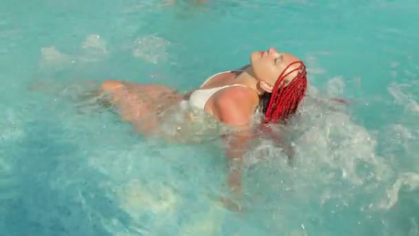 Woman with pigtails in a hydromassage pool — ストック動画