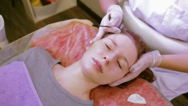 Den kosmetolog kammar och desinficerar klienterna ögonbryn innan korrigering — Stockvideo