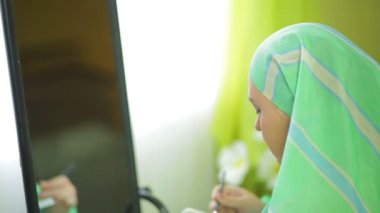 Ayna önünde Müslüman kadın parlak gölgeler de göz makyajı yapar