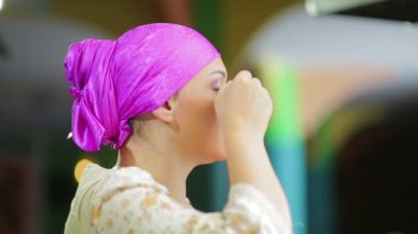 Bir ayna önünde evli bir Jewess bir fırça ile mor gölgeler ile göz makyajı yapar