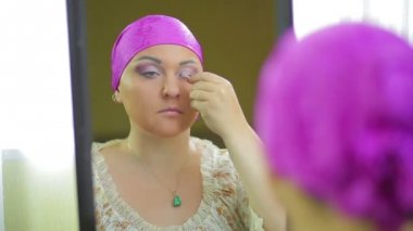 Evli bir Jewess aynaya yansıyan göz farı ile makyaj yapar