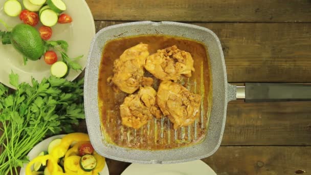 La mano femenina pone verduras en trozos de pollo en una sartén . — Vídeos de Stock