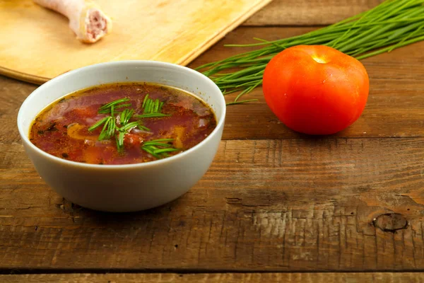 Plat gris de soupe de légumes sur une nappe sur une table en bois . — Photo