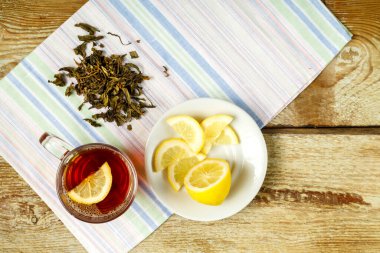 Limonlu, ballı, zencefilli ve peçeteye serpiştirilmiş bir fincan çay..