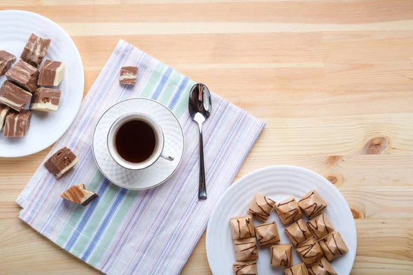 Чашка кофе на салфетках на деревянном столе с круассанами и сладостями . — стоковое фото