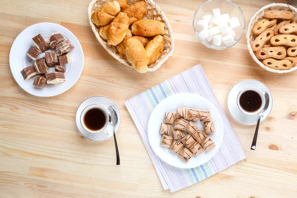 Чашка кофе на салфетке деревянный стол и сладости с сахаром . — стоковое фото