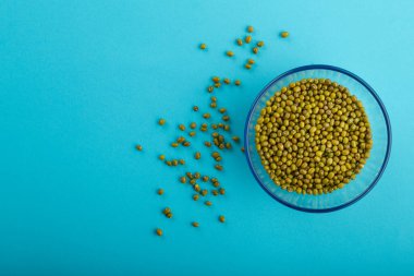 Mavi arka planda yeşil mısır gevreği taneli cam kavanoz..