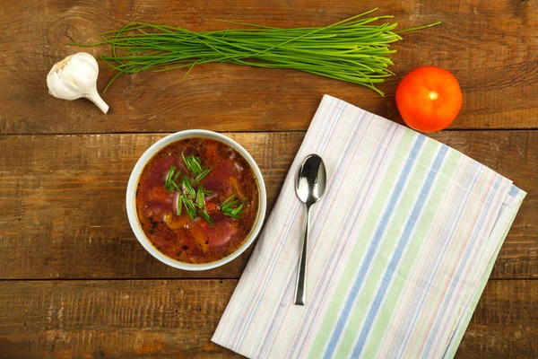 Gri bir tabak sebze çorbası ahşap bir masada masa örtüsü üzerinde.. — Stok fotoğraf
