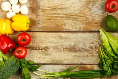 Brokoli sebzeleri, yeşil soğanlar, domatesler ve biberler, sert tahtalardan masanın kenarındaki şampiyonlar.
