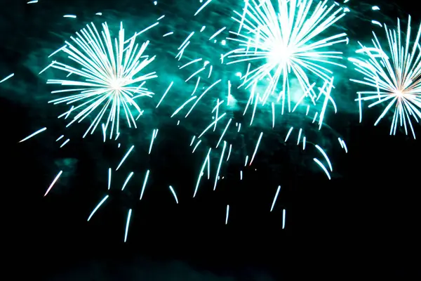 Green effects of bright fireworks in the night sky. Stock Photo