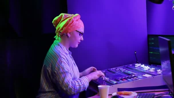 Donna ebrea in un foulard lighting designer programma la luce per lo spettacolo, mangiare fast food — Video Stock