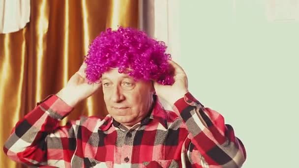 Un homme danse dans une perruque de carnaval avec des boucles violettes — Video