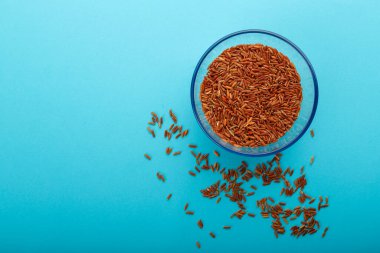 Mavi arka planda kahverengi pirinçli cam kavanoz..