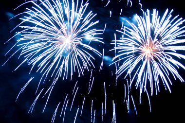 Gece gökyüzünde parlak havai fişeklerin mavi kıvılcımları.