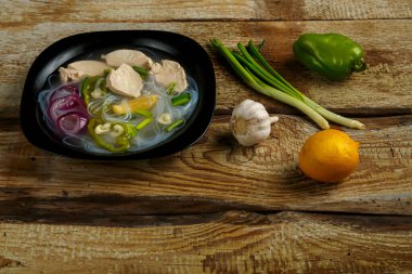 Tahta masadaki tavuklu Vietnam Pho çorbası..