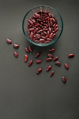 Siyah arkaplanda kırmızı fasulye olan cam kavanoz..