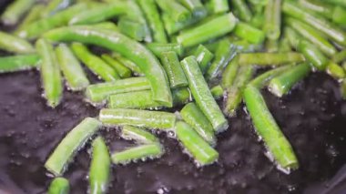 Yeşil fasulyeler tavada kızgın yağda kızartılır..