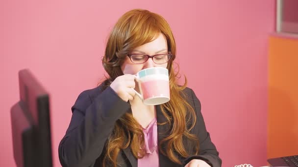 Young woman supervisor in the office speaks on the phone and drinks tea. — Stock Video