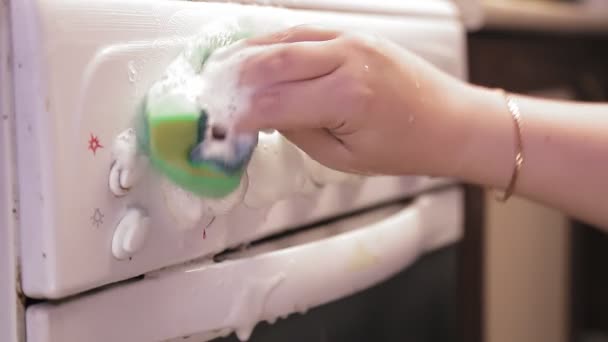Ženská ruka s houbou s čisticím prostředkem myje panel vypínači sporáku. — Stock video