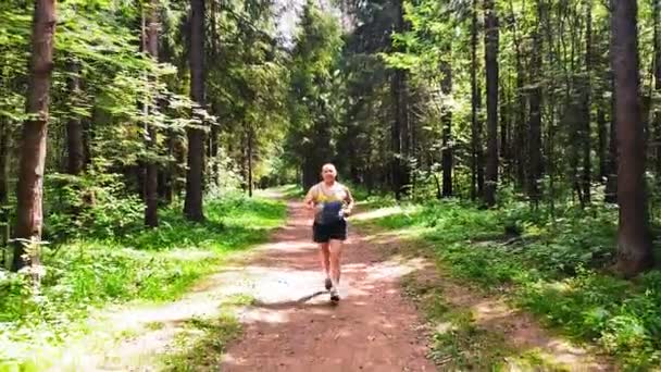 Um homem de sportswear correndo em um parque no verão . — Vídeo de Stock