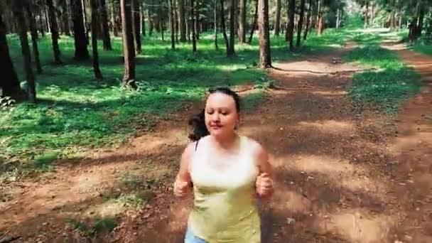 Vrouw in sportkleding joggen in het park in de zomer. — Stockvideo