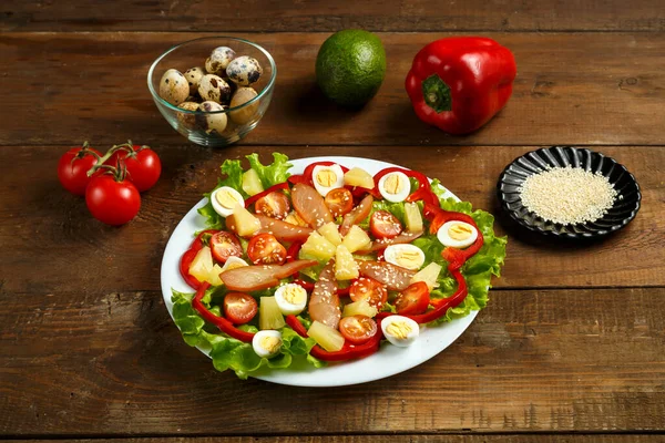 Pan-Asian salad with cherry tomatoes, smoked chicken, pineapple and sesame seeds.