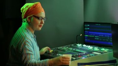 Türbanlı ve gözlüklü Yahudi bir kadın, ışık tasarımcısı, program için ışığı programlıyor.
