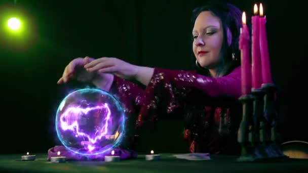 The fortuneteller in magic creates the future on a mirror ball. with magic fire on a black background — Stock Video