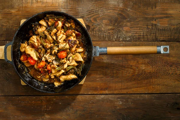 Frying pan with chicken and vegetables in pad Thai sauce. Horizontal photo