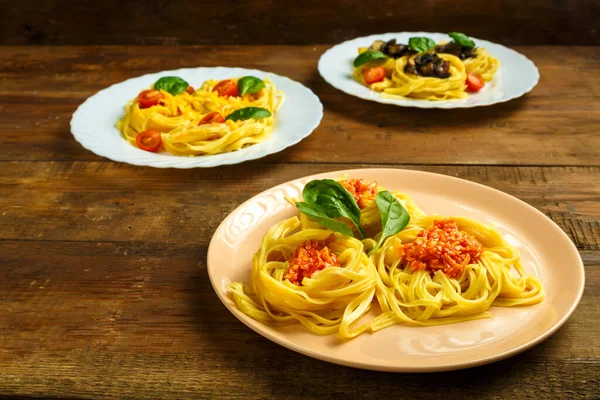 Üç tabak makarna ve değişik dolgu malzemesi.